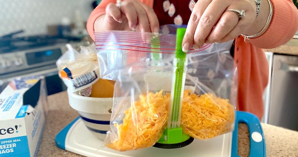 hands holding a plastic bag with green stand up baggy rack 