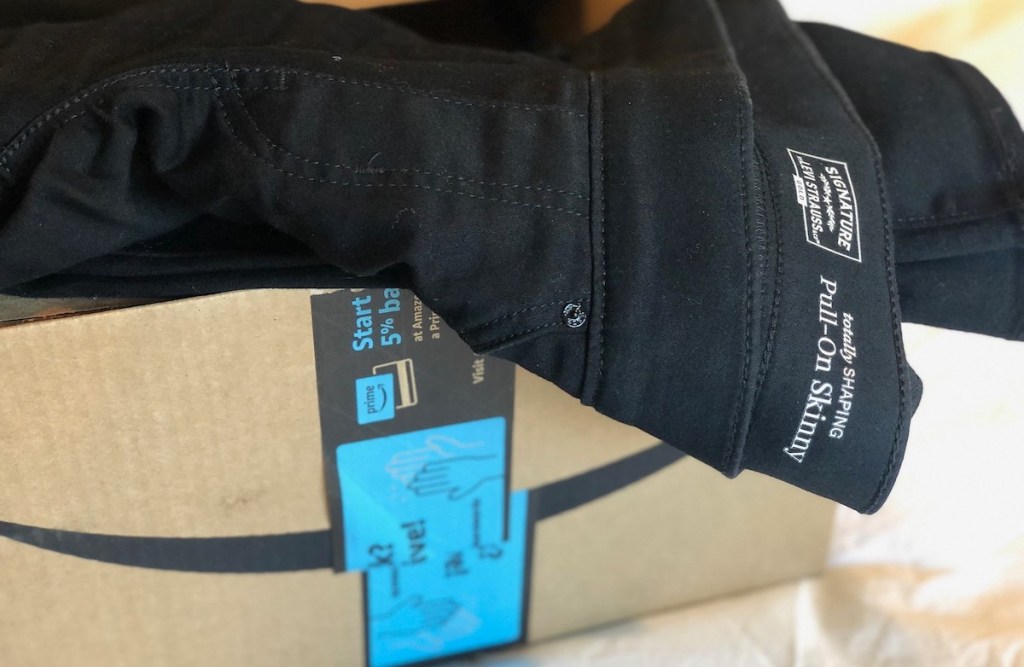 black pair of jeans sitting in Amazon box