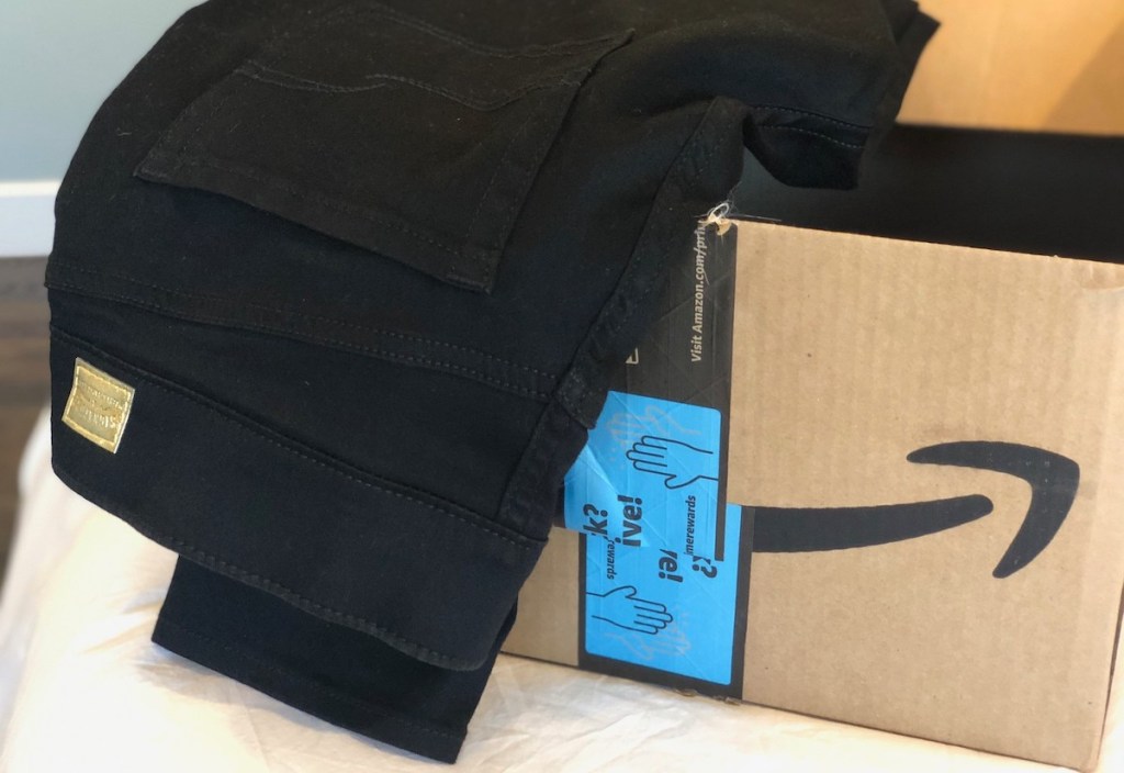 pair of black jeans sitting in amazon box