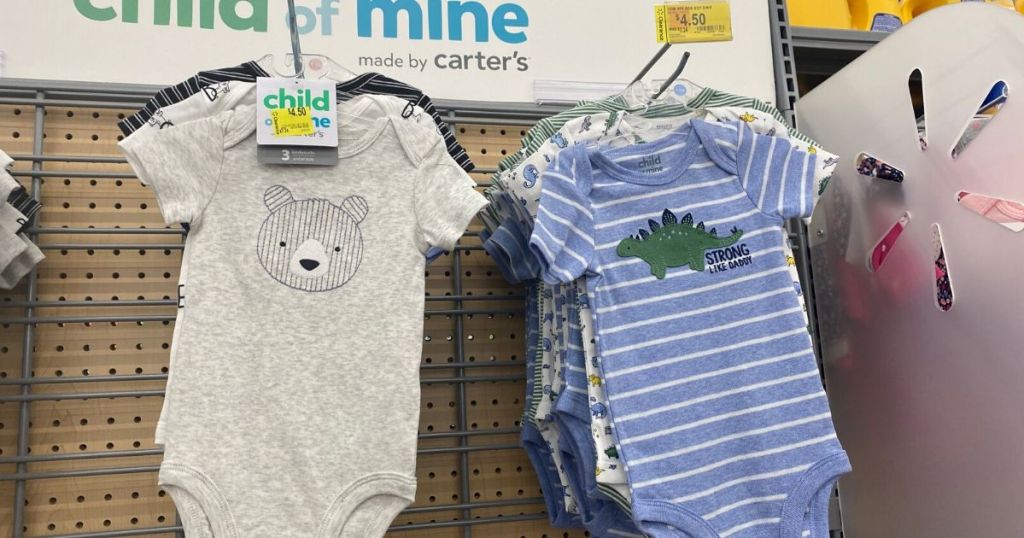 3 piece sets of onesies for babies hanging up on wall at store 