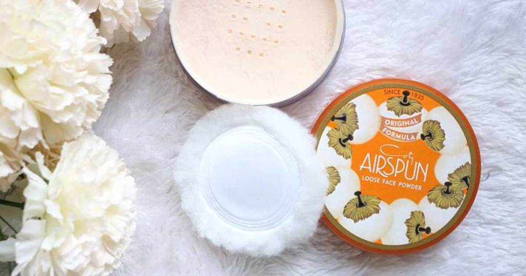 Coty Airspun Loose Face Setting Powder next to white flowers