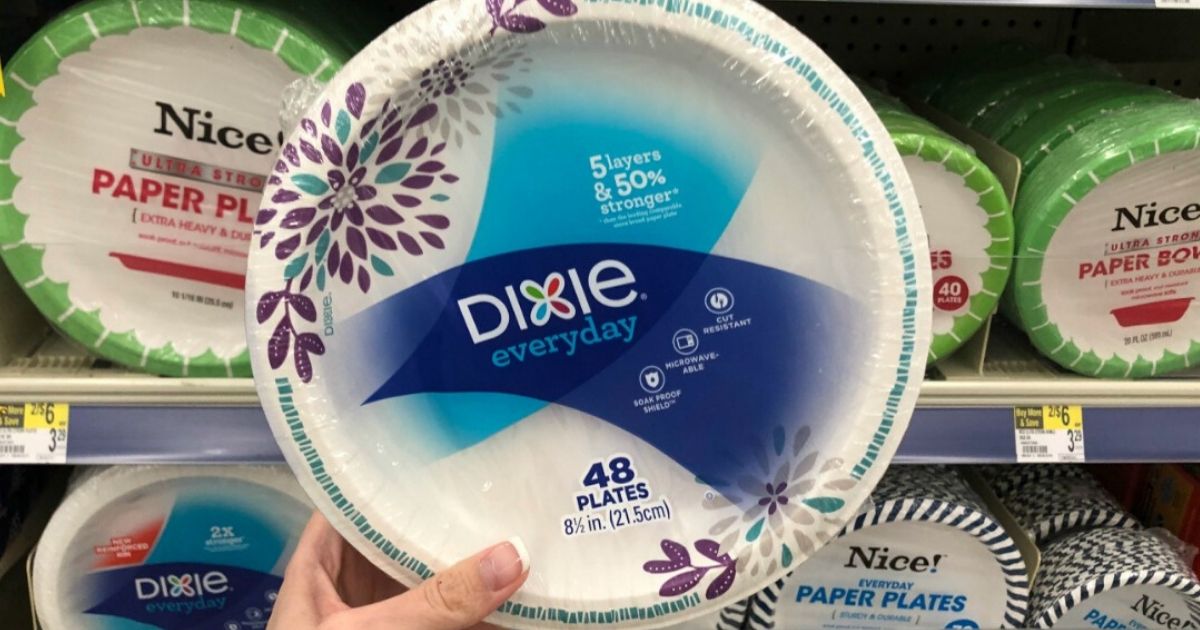 woman's hand holding up sealed package of paper plates at the store in aisle