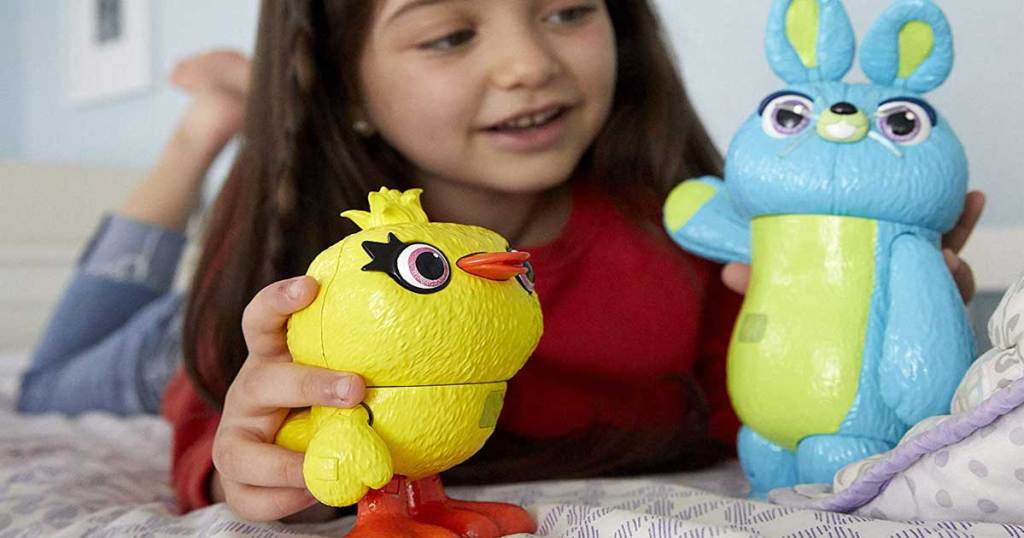 girl playing with a duck and bunny toy