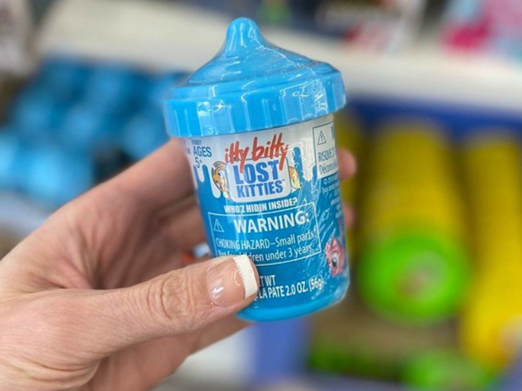 hand holding very small blue container by store display