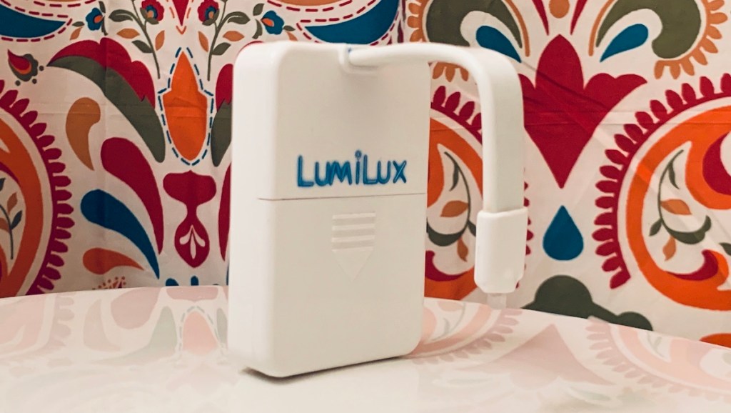 white plastic box with lumilux and paisley blanket in background