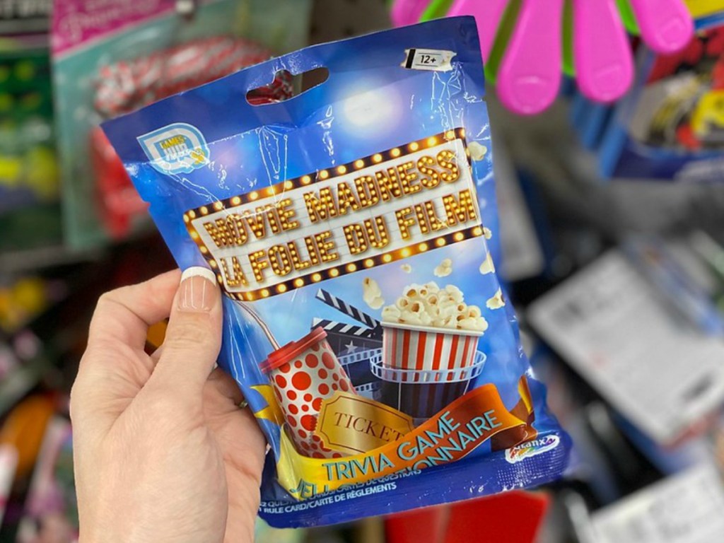 hand holding small package with movie trivia game inside