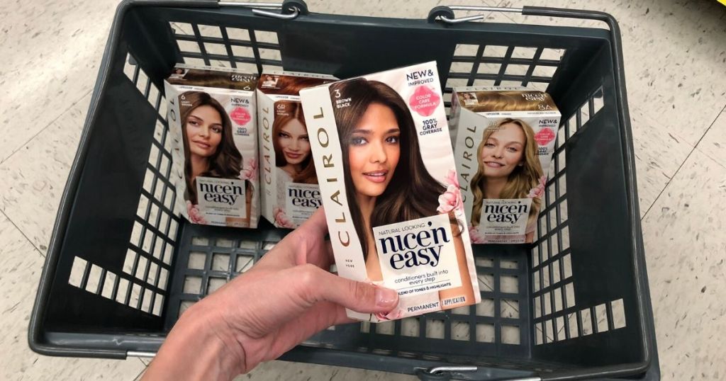 shopping basket with 3 boxes of hair dye in it and woman's hand holding box of hair dye over basket 