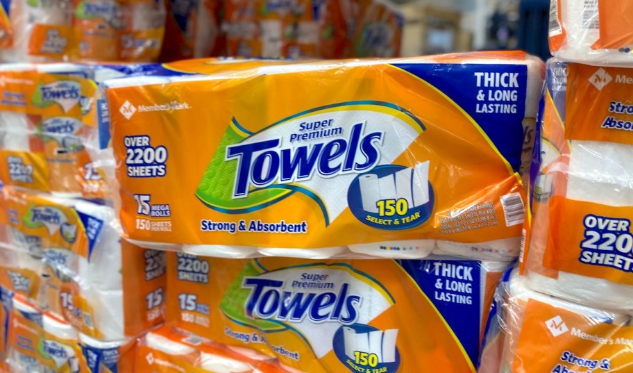 packages of orange paper towels stacked on store bulk aisle