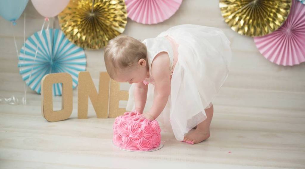 girl wearing white dress touching icing