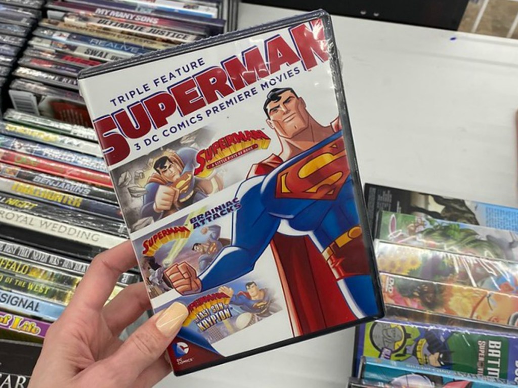 hand holding movie with Superman pictured on it