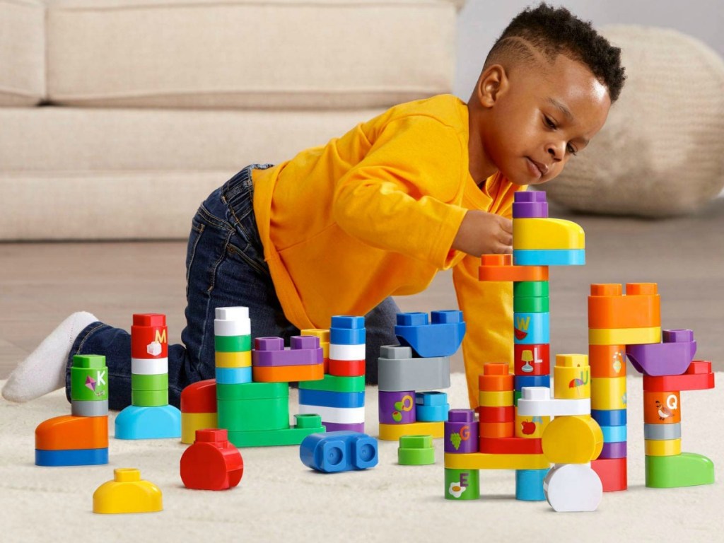 Young boy playing a set of multi-colored blocks