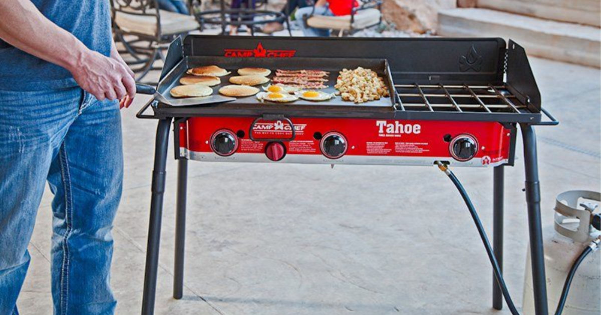 man cooking on Camp Chef Tahoe 3-Burner Propane Camp Stove with Griddle