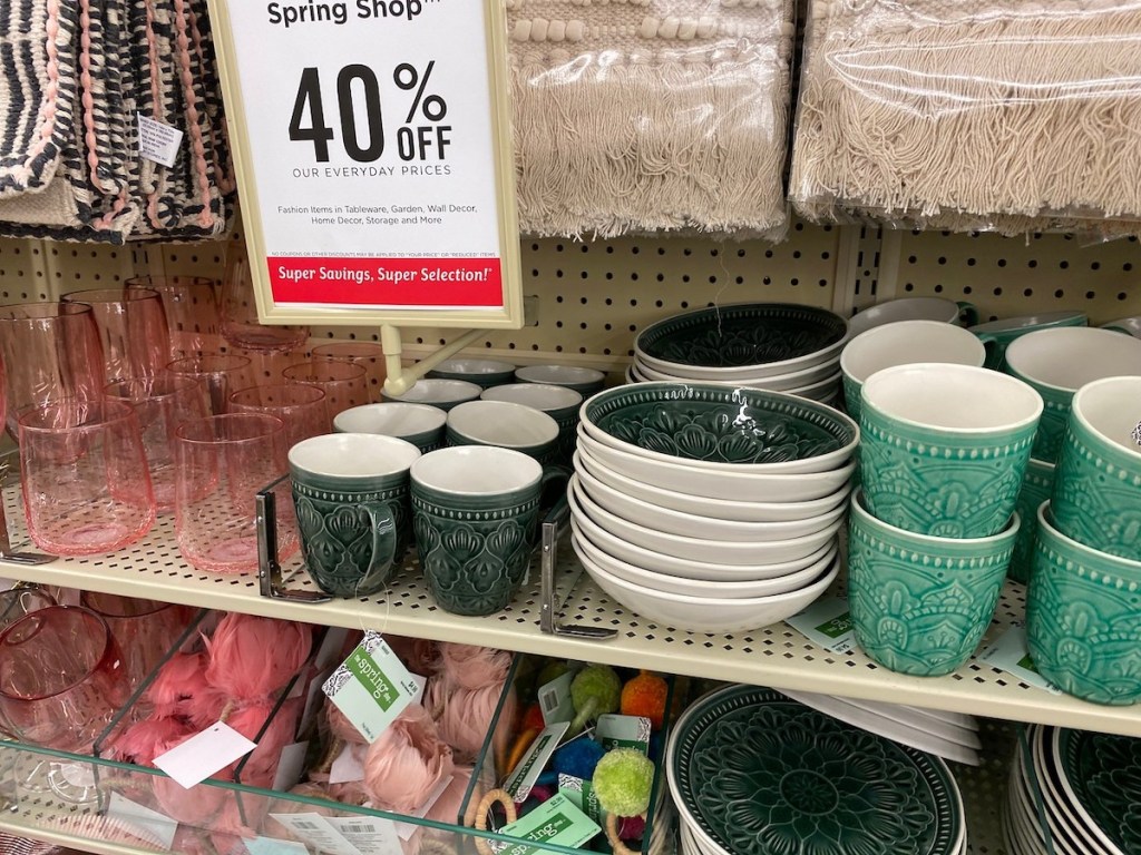 hobby lobby spring shop sign with dark green mugs, plates, bowls