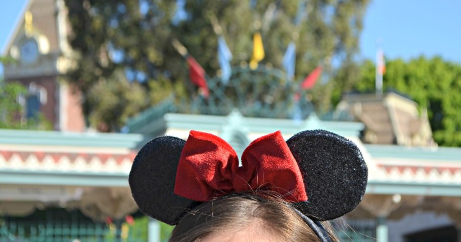 Girl wearing Mickey Ears with red bow at Disneyland