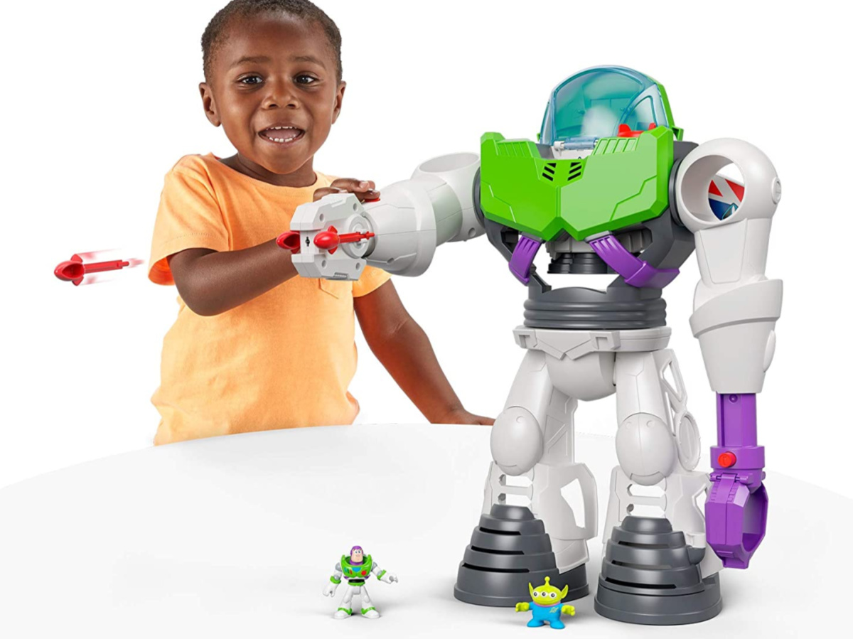 young boy playing with robot toy on white table