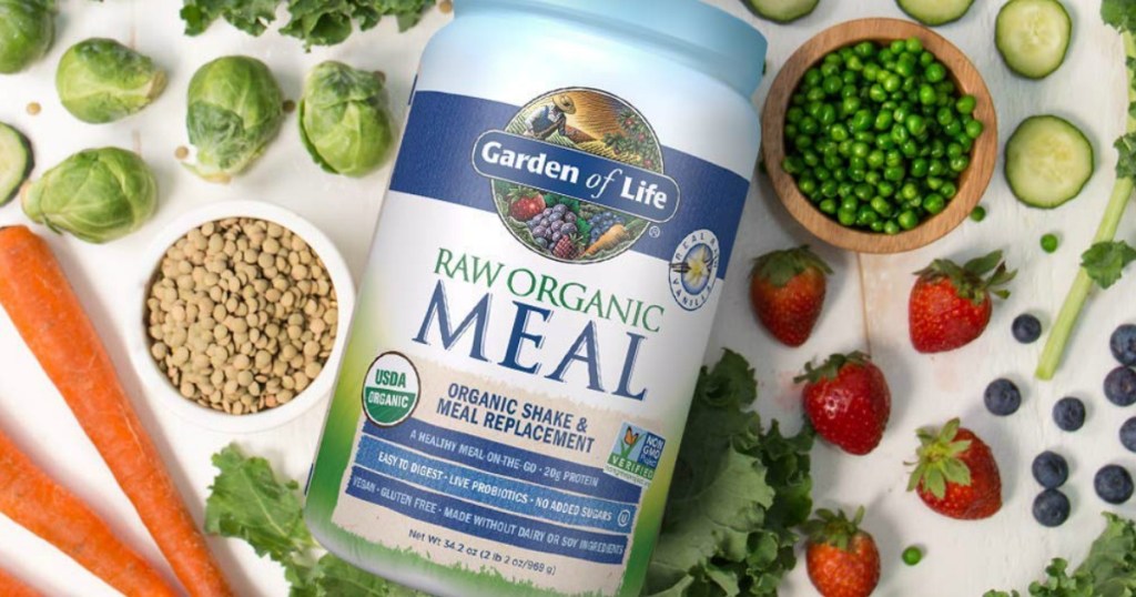 Large canister of raw organic meal replacement near plants and vegetables on surface