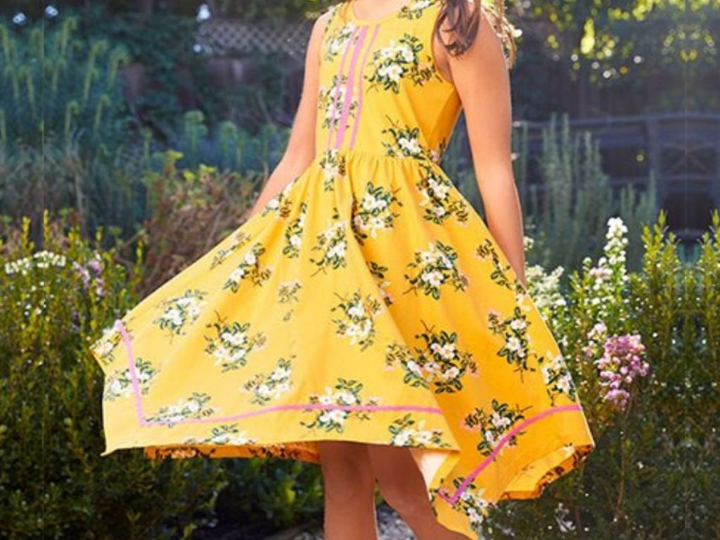 girl twirling in hankerchief dress outside 