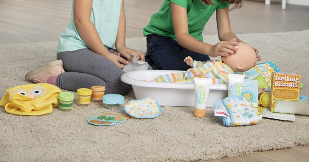 young girls playing with doll set