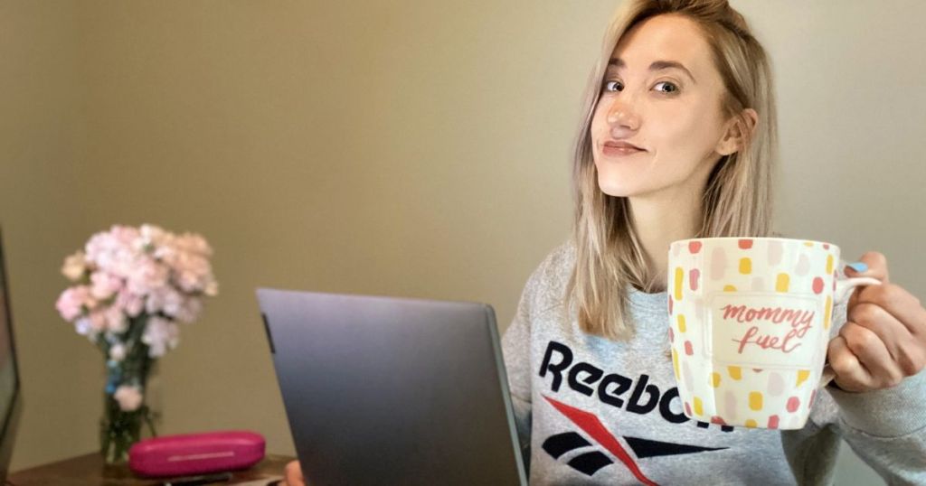 Mom working from home office, holding coffee mug and smiling