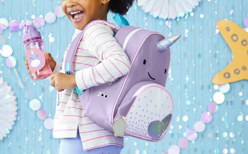 Young girl wearing a narwhal themed backpack