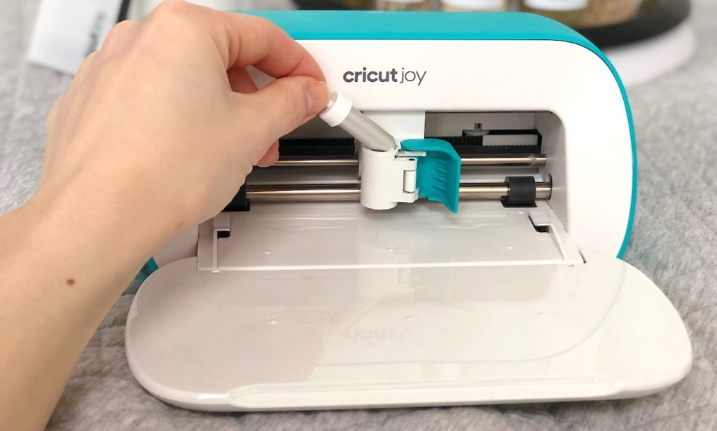 hand holding a silver cutter of label printer