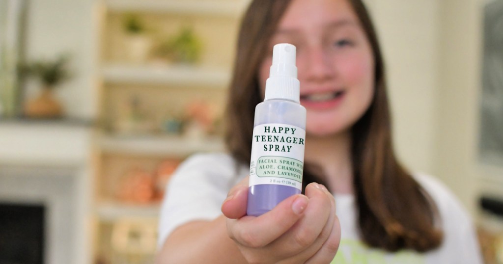 girl holding a bottle of happy teenager spray