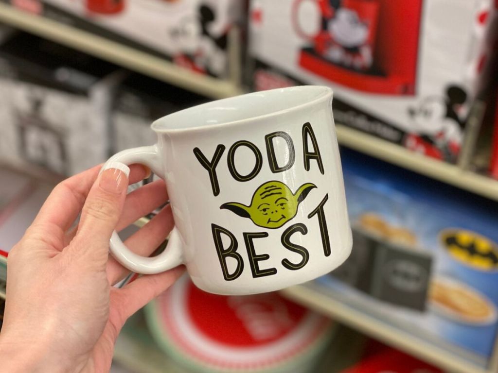 woman's hand holding coffee mug in store aisle 