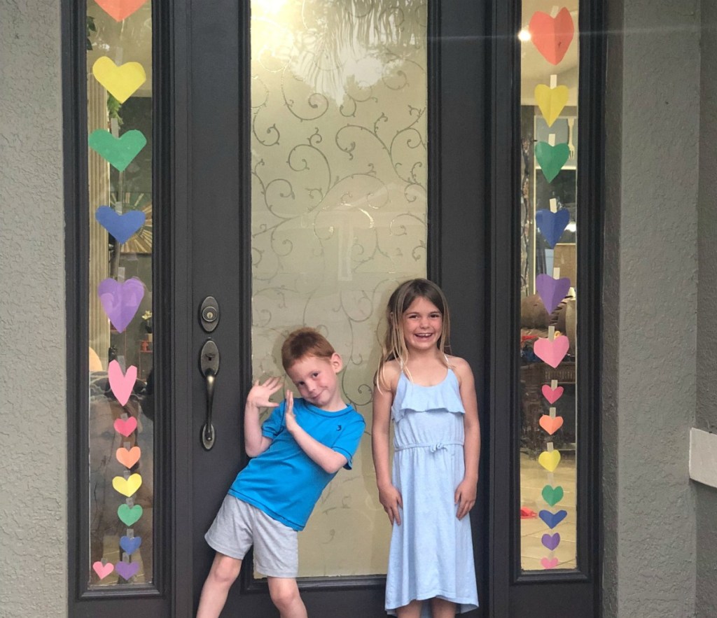 kids decorating door with hearts during coronavirus 