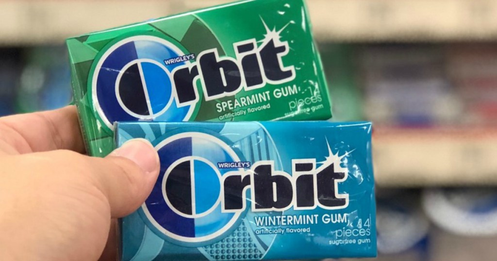 hand holding two packs of gum in a store