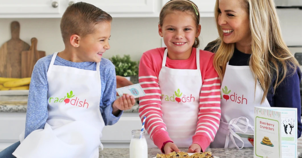 two kids and a mom in the kitchen with aprons