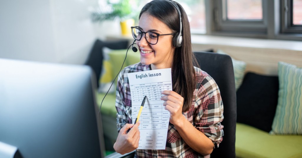 teacher sitting at desk teaching online