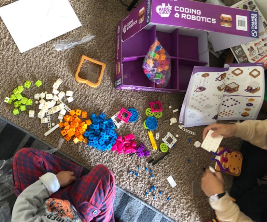 opening purple box full of colorful toy pieces to game