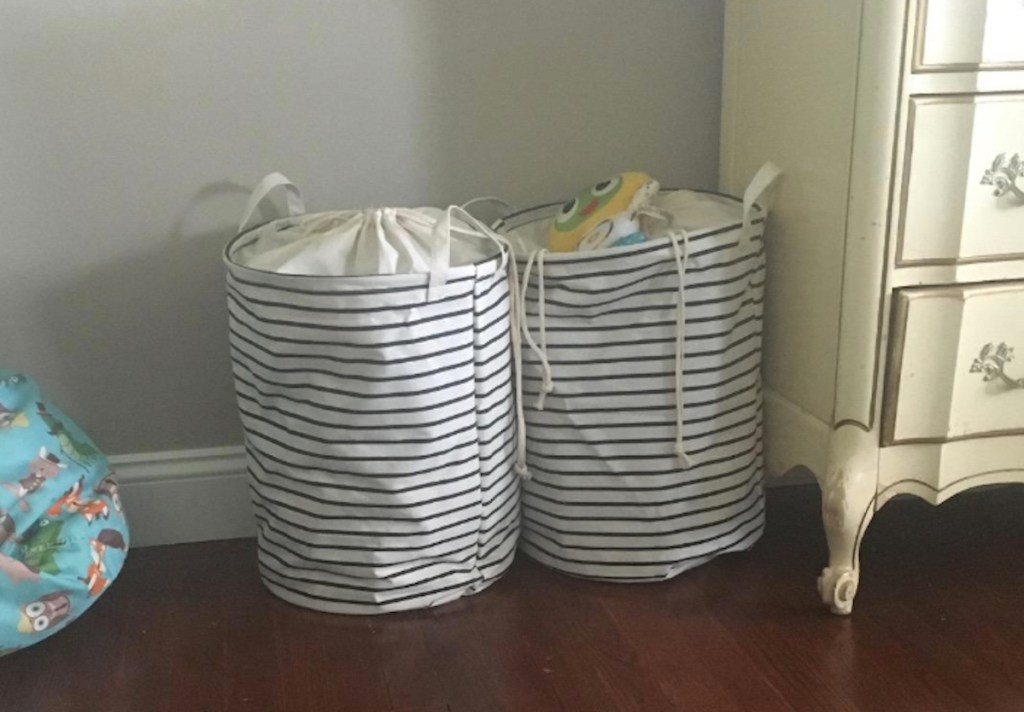 stripes white and blue toy basket hampers sitting next to dresser