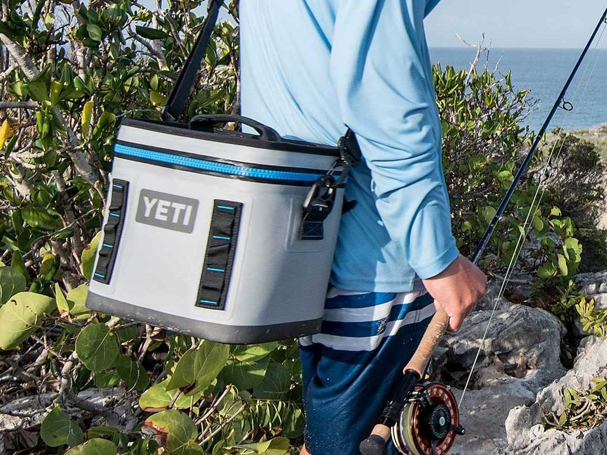 yeti flip 8 cooler on man's back by ocean