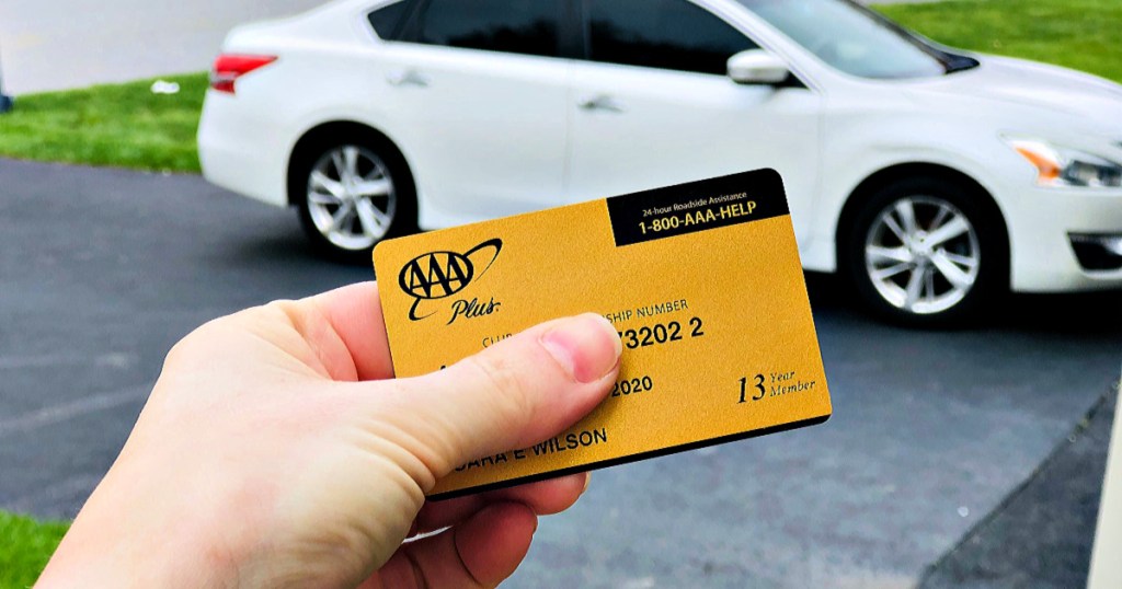 AAA Gold Membership in person's hand in front of white car