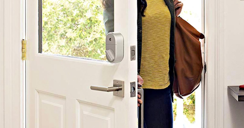 woman in yellow sweater walking through front door with keyless smart lock installed on deadbolt