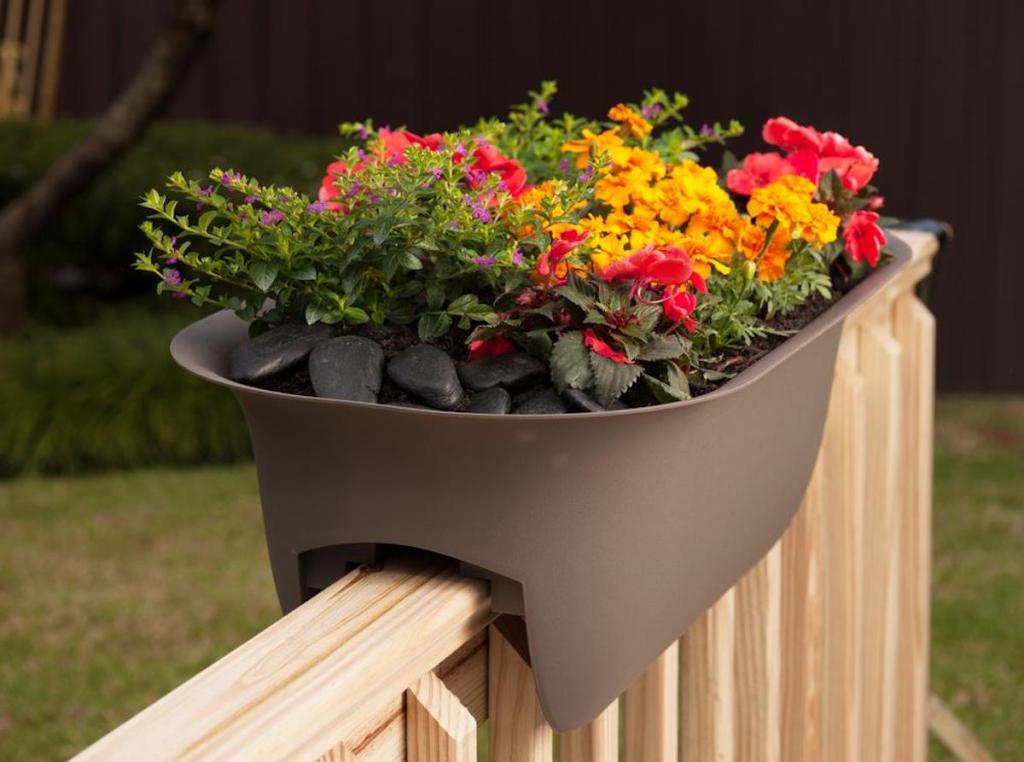 Bloem Chocolate Modica Plastic Deck Rail Planter with flowers inside of it sitting on chair railing