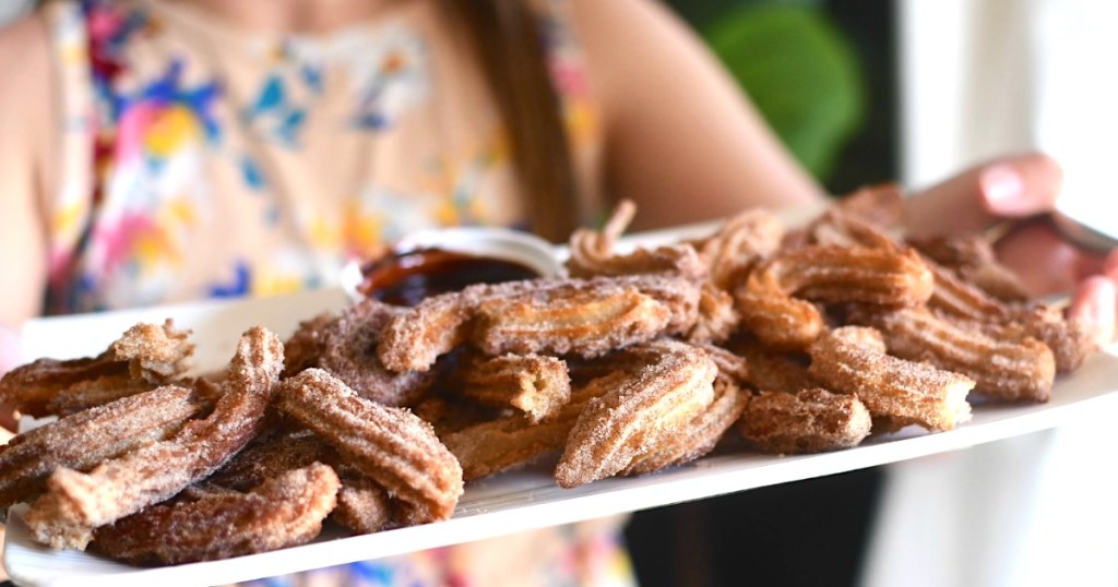 holding platter of Disney churro bites 