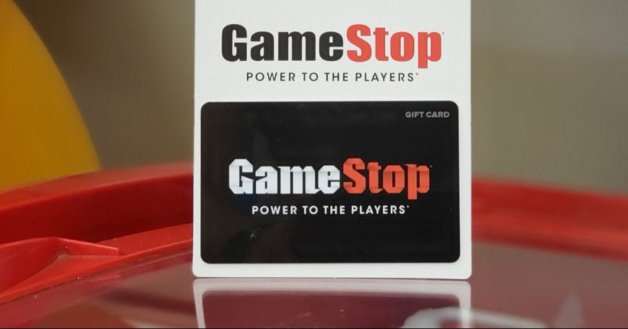 GameStop gift card standing on red table