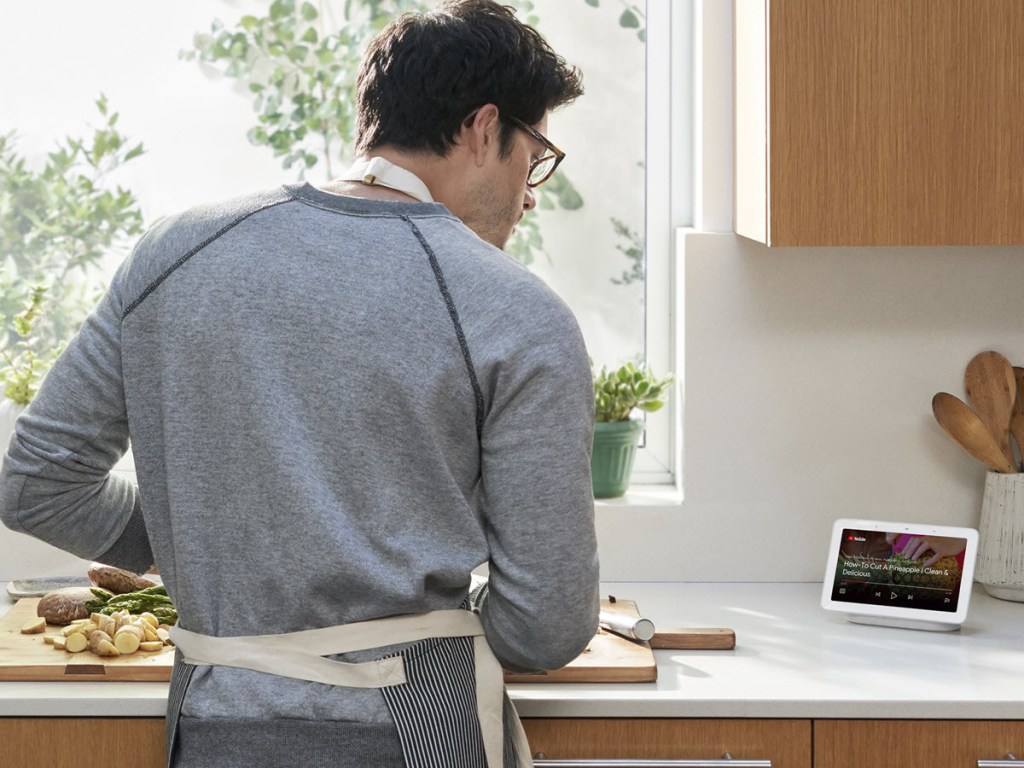 man looking at a Google Nest Hub on his counter