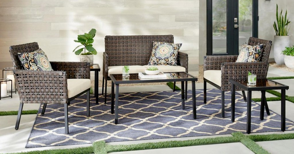 brown wicket patio set with beige cushions on a blue outdoor rug