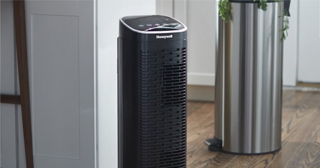 black air purifier in kitchen next to trash can