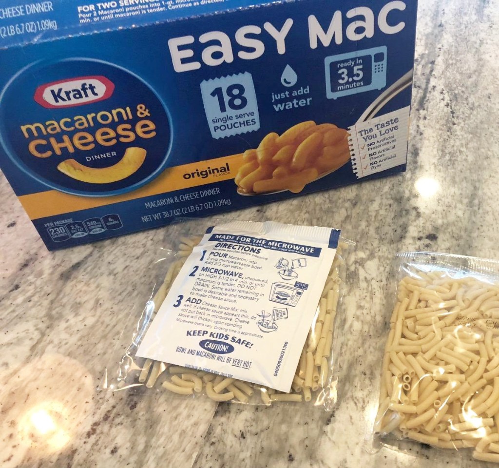 blue box of kraft easy mac packets with packets of dry pasta on kitchen counter