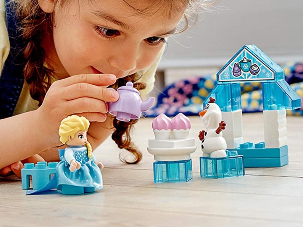 young girl playing with Disney LEGO toy set