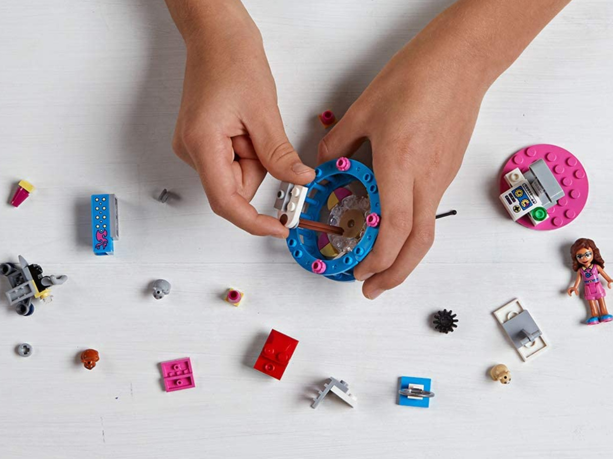 child's hands playing with toy lego set