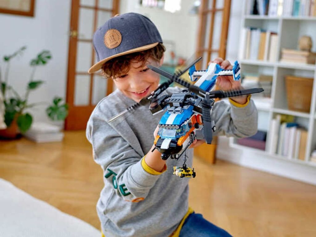 little boy playingwith Lego helicopter