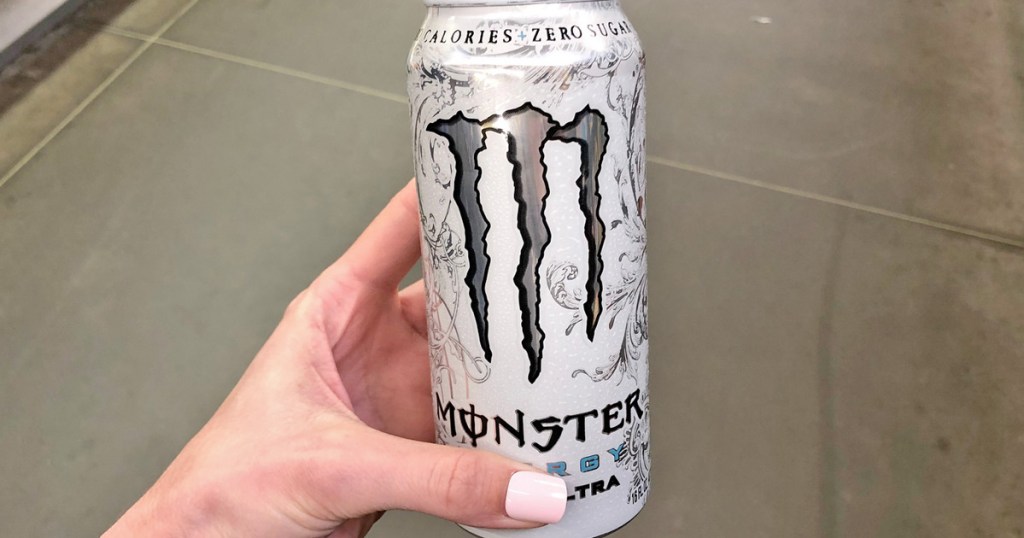 girl with light pink nails holding white can of monster energy drink