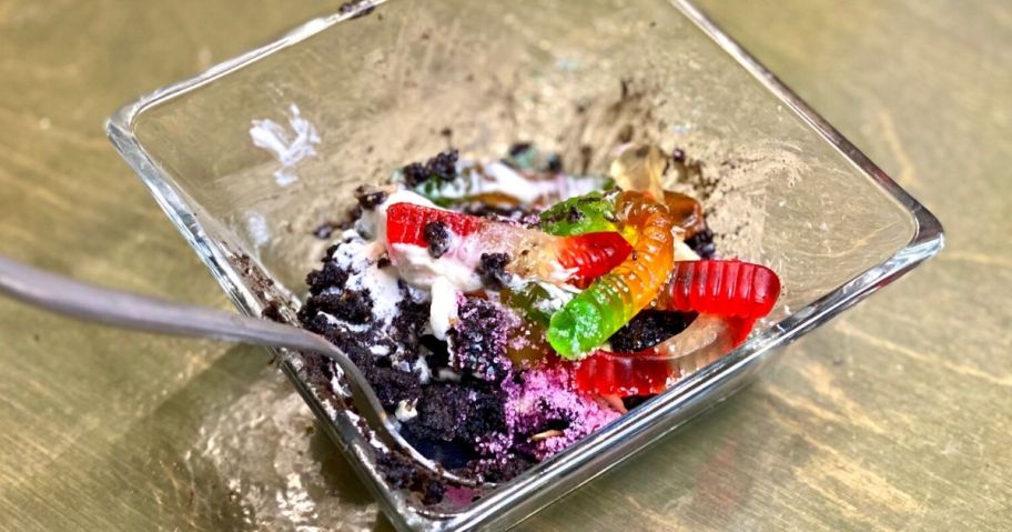 Oreo mug cake in a bowl with gummy worms and whipped cream on top