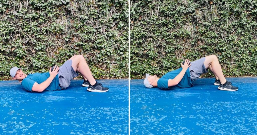 Man laying on ground and demonstrating pelvic thrusts with a weight on hips