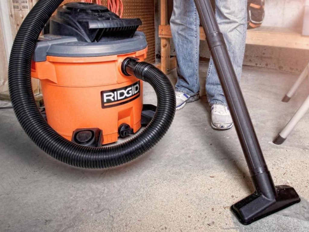 man using shop vac on cement floor